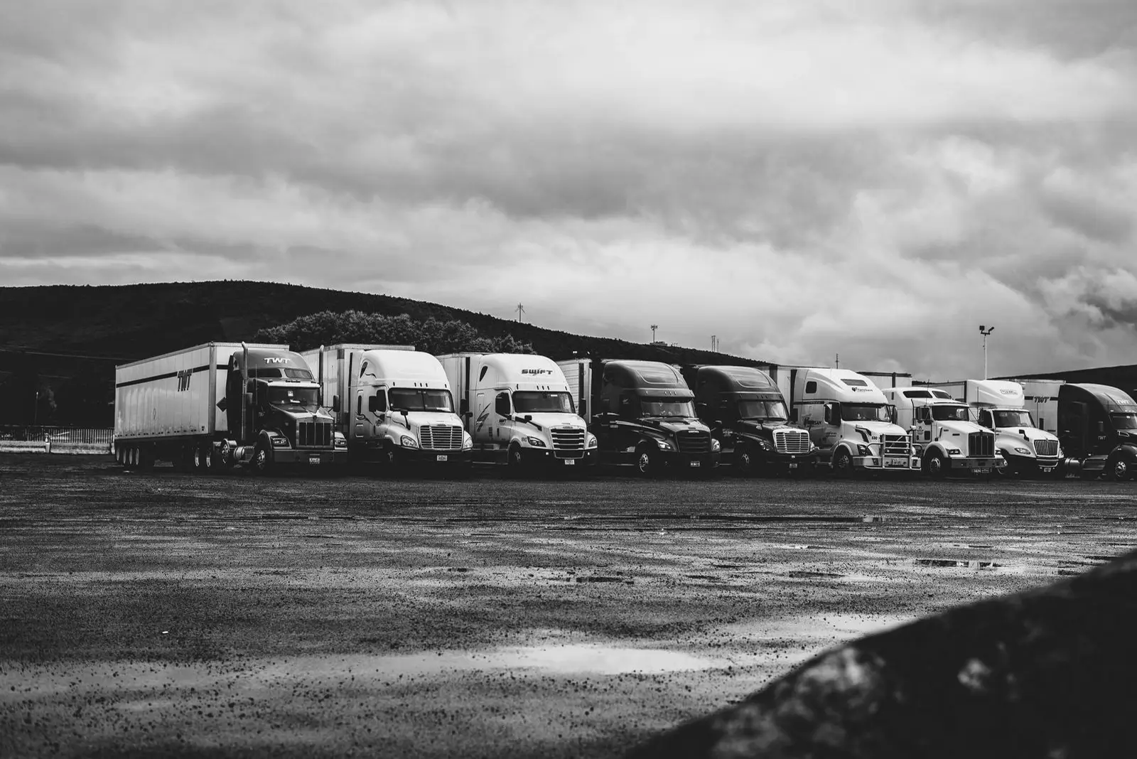 A row of semi trucks parked under a heavy sky (representative photo)