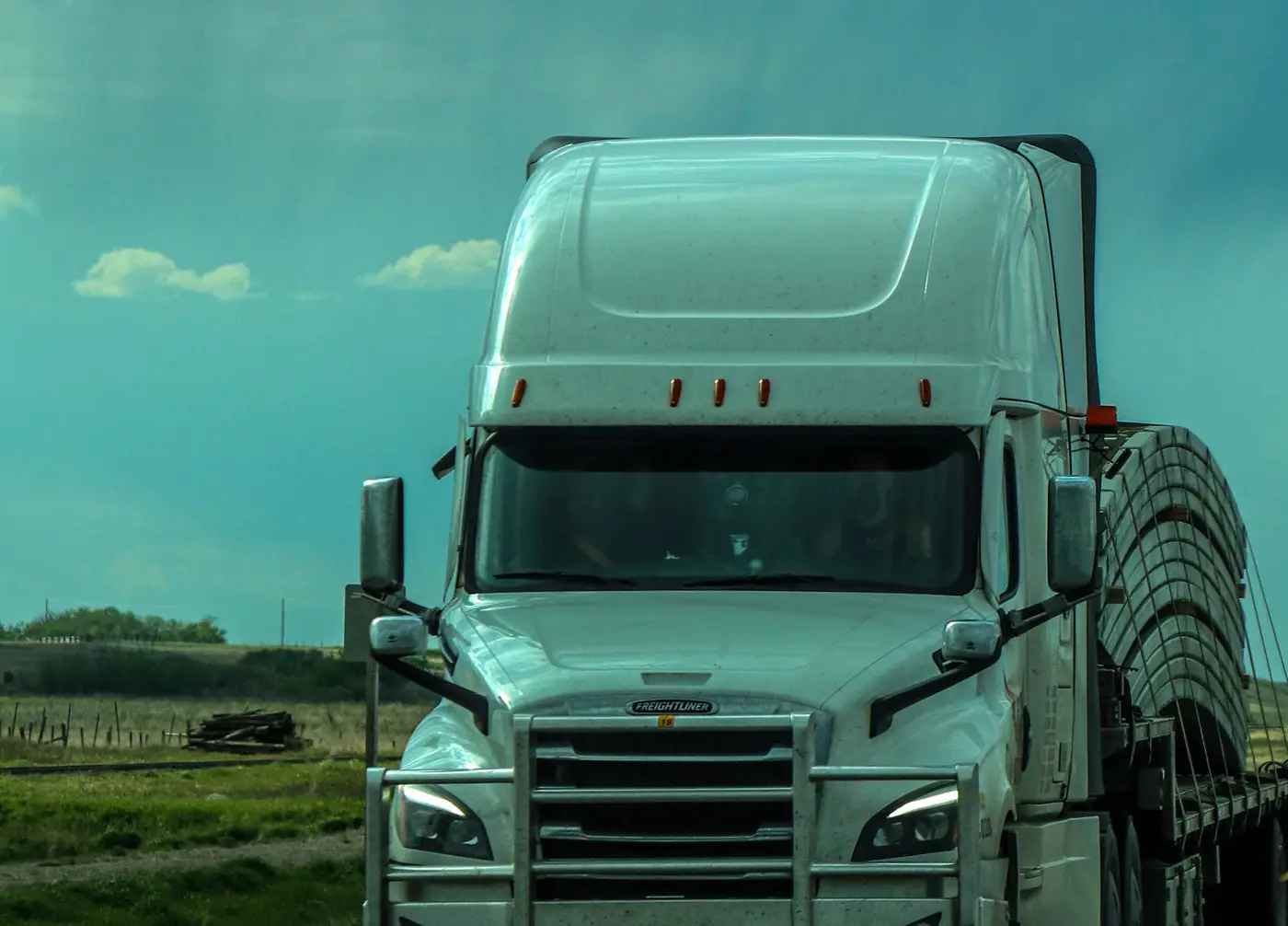 A semi truck on an open road beside green fields (representative photo)